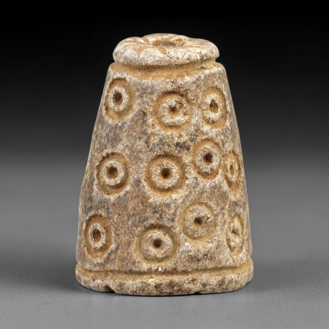Ancient Steatite Amulet - Near Eastern Concentric Circles, 45AK: Crafted from steatite, this conical amulet features incised concentric circle motifs arranged in horizontal rows across its tapered body, with a suspension hole piercing the top rim for wear. Attribut