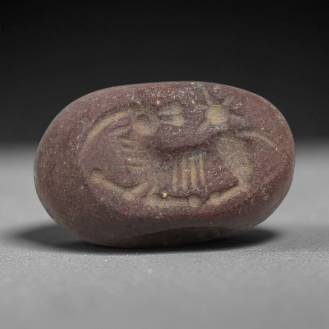 Ancient Stone Hemispherical Stamp Seal - Near Eastern Animal Figure, 5ZT: Crafted from dense, reddish-brown stone, this hemispherical stamp seal bears incised carving of a stylized animal figure, likely a composite mythical creature or bird, with distinct head crests, segme