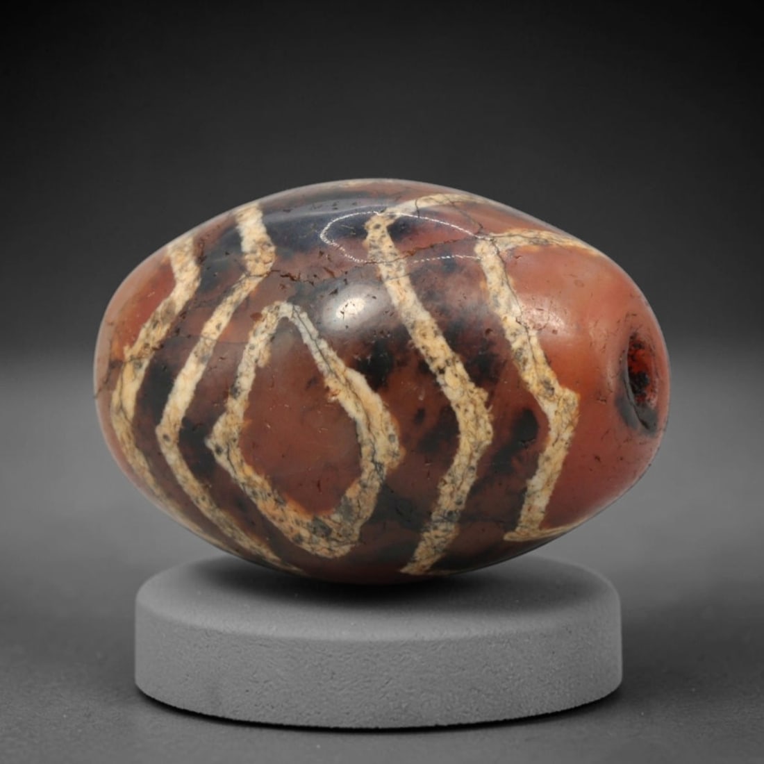 Ancient Carnelian Etched Dzi Bead - Himalayan Amulet, 84XV: Crafted from rich translucent carnelian, this bead features bold etched white wavy and teardrop-shaped motifs, executed in the traditional Himalayan Dzi bead technique. The form is an ovoid shape with