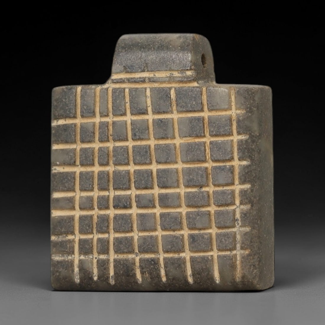 Ancient Stone Grid Amulet - Near Eastern Pendant, 28AE: This artifact is a carved stone amulet of Near Eastern origin, crafted from a mottled greyish stone with lighter mineral veining and a matte, aged patina. Its form features a thick, square-shaped body