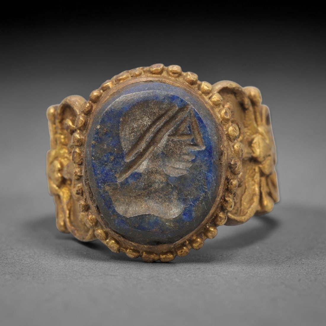 Antique Qajar Dynasty Brass Lapis Lazuli Intaglio Ring - Size 9 US, 71ZX: This antique Qajar dynasty brass intaglio ring features an oval lapis lazuli intaglio inset carved with a detailed profile portrait, set within an ornate brass mount adorned with a beaded border and e