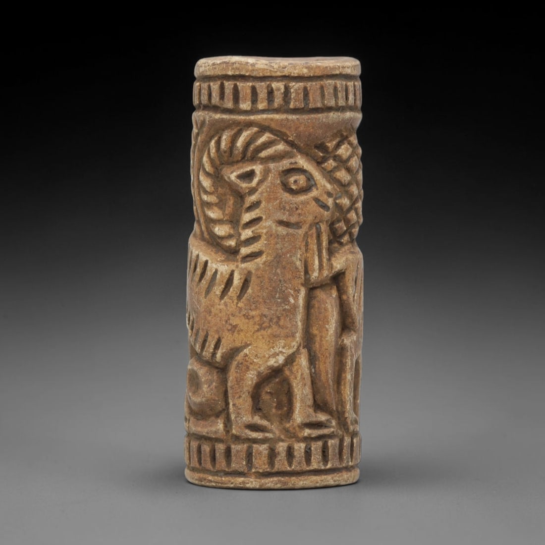 Ancient Stone Cylinder Seal - Near Eastern Ram Relief, 16WJ: Carved from a fine-grained, pale beige stone, this artifact takes the form of a cylindrical seal, adorned with a deeply carved relief scene. The central motif is a stylized ram, depicted with prominen