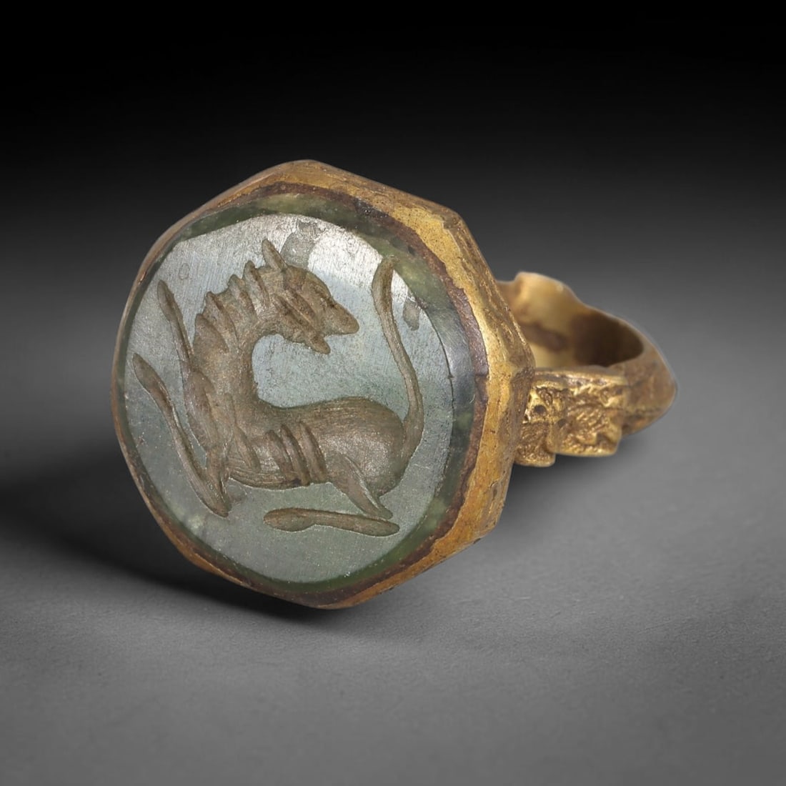 Antique Qajar Dynasty Green Stone Feline Intaglio Ring - Size 8 US, 81FY: Crafted from gilt brass with a faceted octagonal bezel, this ring features a carved green stone intaglio at its center, incised with a detailed stylized feline (cat) motif-an amuletic symbol of protec