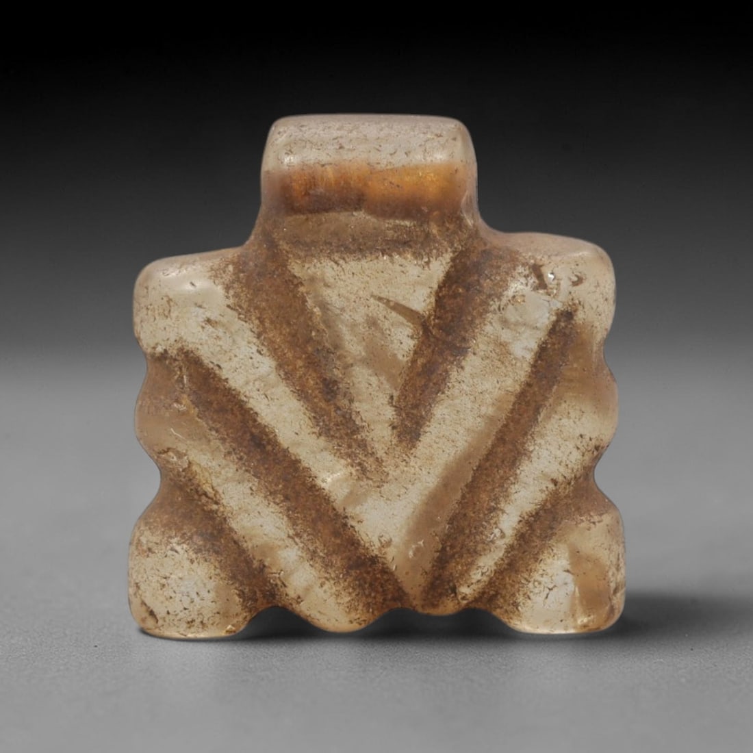 Ancient Rock Crystal Fly Amulet - Near Eastern Figurine, 12XT: This amulet is carved from translucent rock crystal with natural earthy inclusions and a weathered patina across its surface, executed in a stylized, geometric form that emphasizes the fly's iconic fe