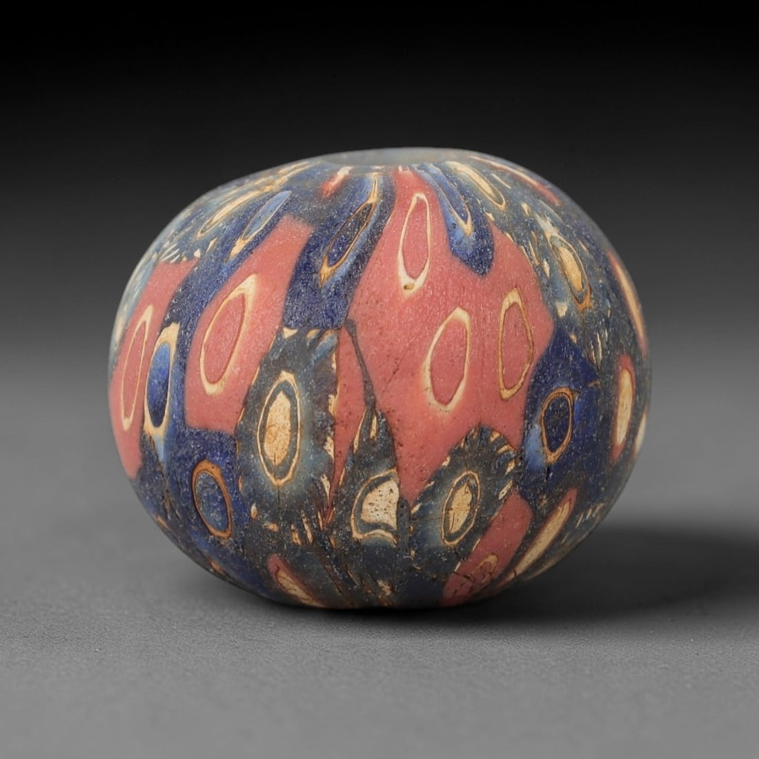 An Ancient Glass Eye Bead - Egyptian Royal Amulet Bead, 35ZM: This remarkable bead, measuring a substantial 2.2 cm (0.87 in), is a masterwork of Egyptian polychrome glass craftsmanship, utilizing the sophisticated core-formed and trailed techniques. Its spherica