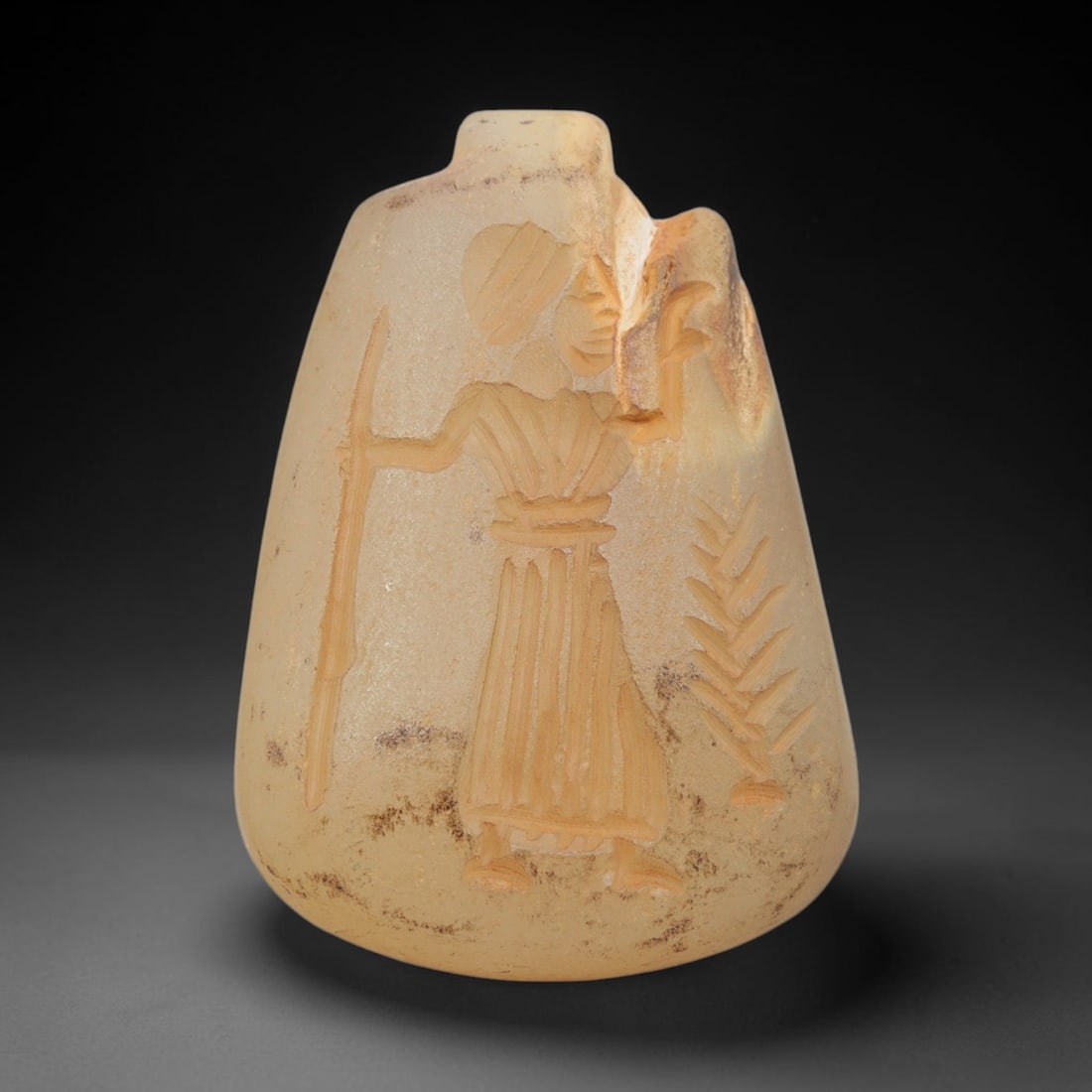 Ancient Chalcedony Amulet - Near Eastern Human Figure, 46ZX: Carved from translucent chalcedony, this amulet features a relief depiction of a standing human figure, likely a warrior or deity, holding a staff or spear in one hand and a raised object in the other