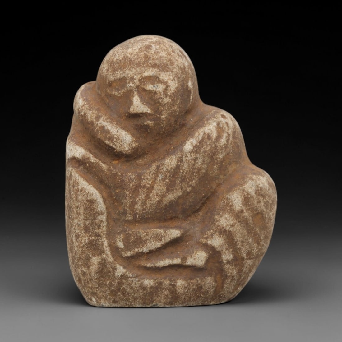 Ancient Stone Edo Monk - Japanese Buddhist Figurine, 46FX: Carved from a light-colored, granular stone with a weathered, earthy patina, this artifact depicts a seated Edo-period Buddhist monk, wrapped in a hooded robe with incised linear folds defining the dr