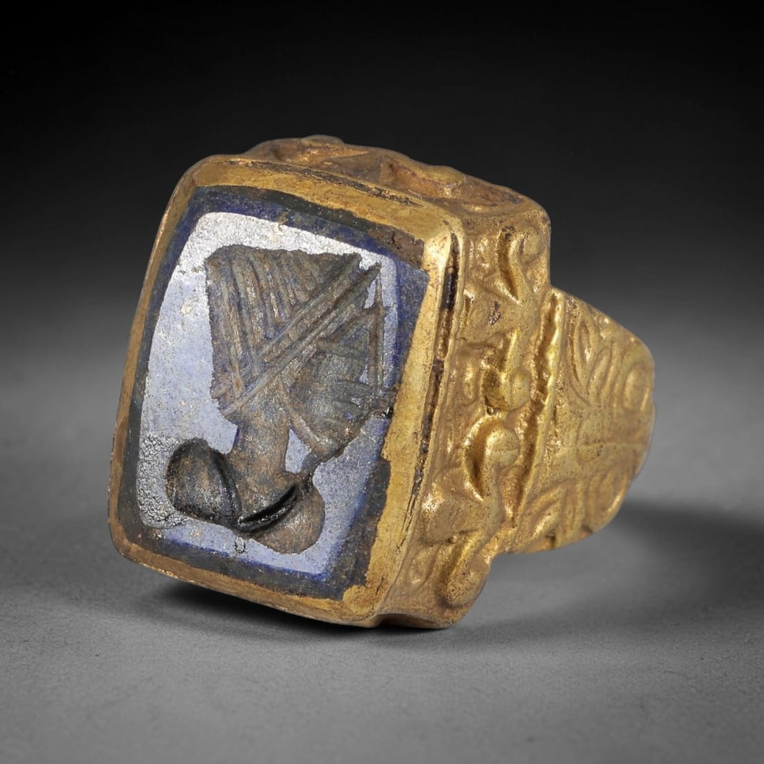 Antique Qajar Dynasty Lapis Lazuli Intaglio Brass Ring - Size 7 US, 79BA: Crafted from brass, this ring features a square-set lapis lazuli intaglio panel carved with a profile figure, executed in the distinctive Qajar style. The brass band displays ornate, relief-carved met