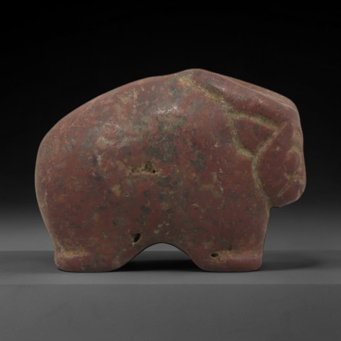 Ancient Red Stone Ram - Indus Valley Zoomorphic Amulet, 84XP: Carved from dense, granular red stone, this miniature zoomorphic amulet depicts a stylized ram, a recurring motif in Indus Valley iconography associated with fertility and ritual symbolism. The form i