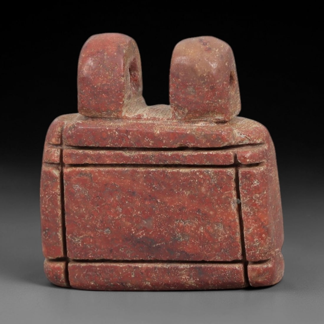 Ancient Red Stone Box Amulet - Near Eastern Pendant, 25AE: This artifact is a carved red stone box amulet of Near Eastern origin, crafted from a rich terracotta-hued stone with natural mineral inclusions and earthy patination. Its form consists of a rectangul