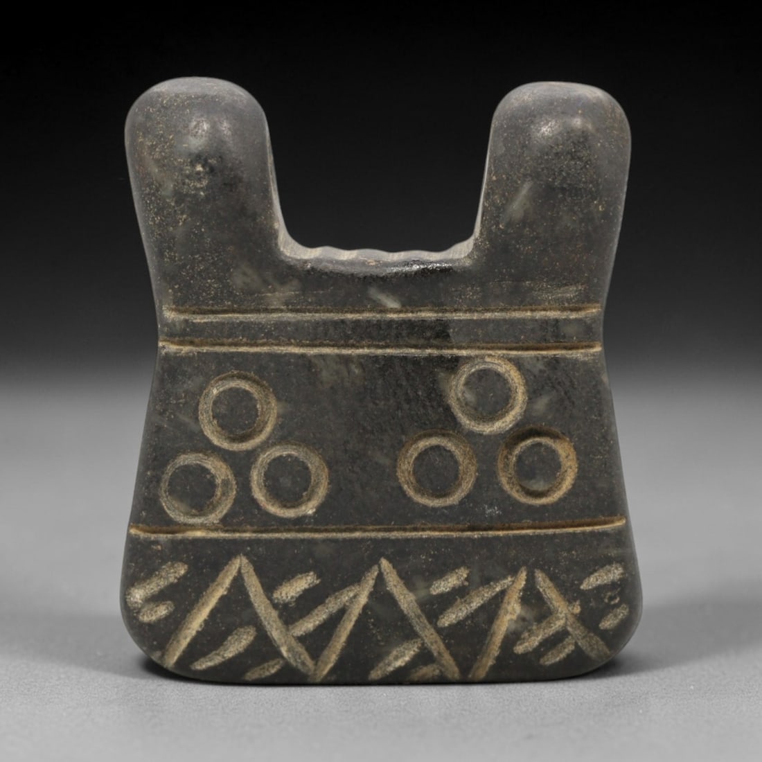Ancient Mesopotamian Black Stone Double Horned Amulet - Carved Pendant Figure, 45ZW: This amulet is carved from a dense, dark grey-black stone with natural mineral inclusions, likely steatite or serpentine, featuring a distinctive double-horned (or double-peaked) form. The piece is ad