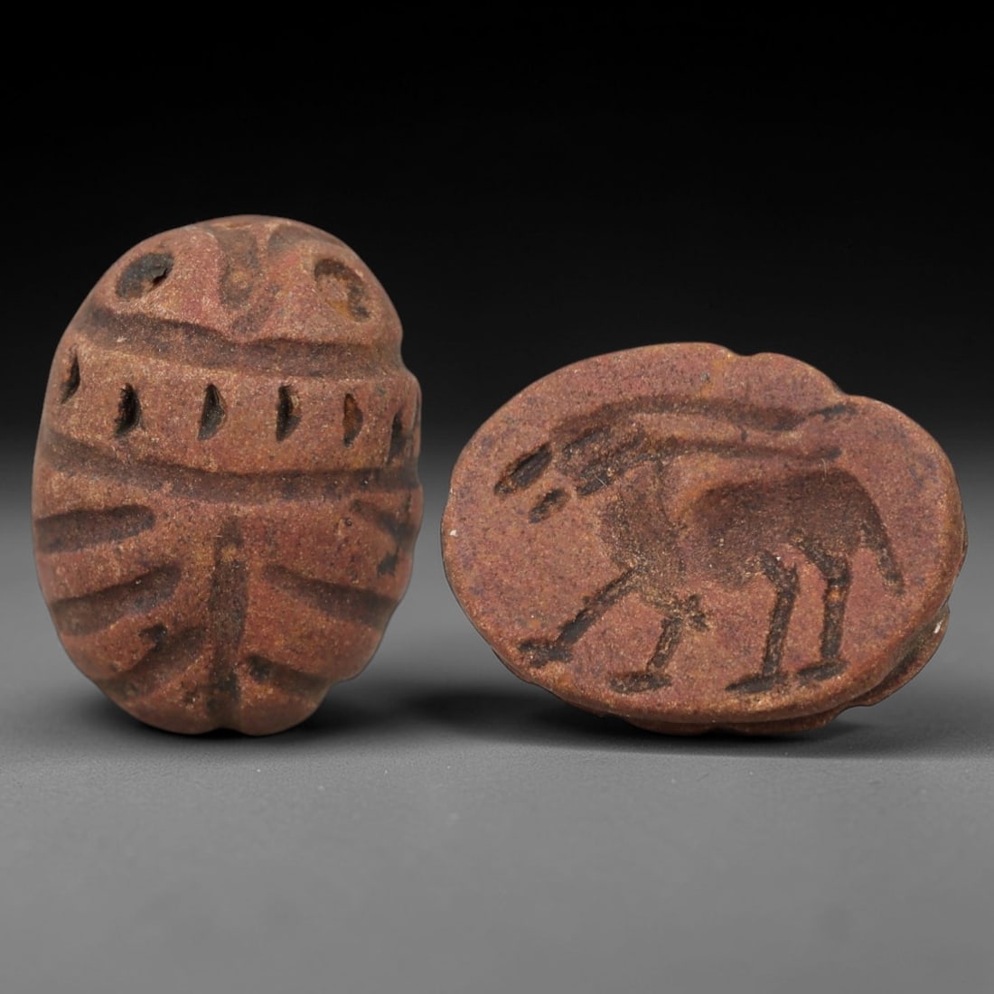 Ancient Steatite Scarab Stamp Seal - Near Eastern Gazelle Figure, 72AM: Carved from reddish-brown steatite, this Near Eastern scarab stamp seal features a dorsal scarab pattern with incised linear wing segments and decorative perforations, while the ventral face depicts a