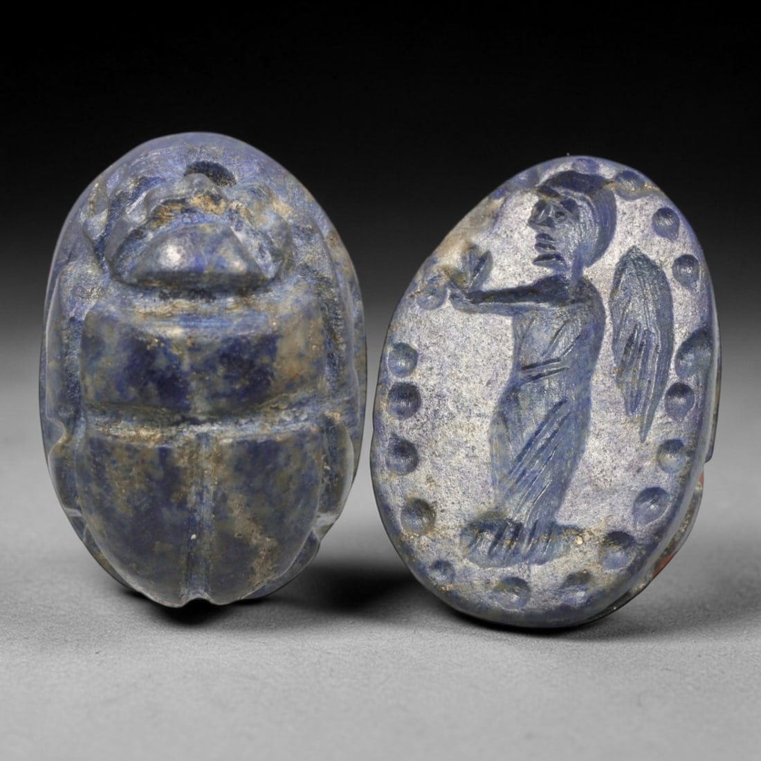 Ancient Lapis Lazuli Scarab - Near Eastern Winged Figural Seal, 25XT: This artifact is hand-carved from lapis lazuli, employing traditional ancient lapidary techniques consistent with Near Eastern Bronze Age seal craftsmanship. The object takes the form of a scarab beet