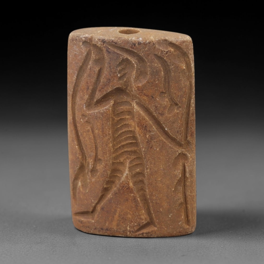 Ancient Schist Double Convex Bead - Perforated Stone Bead, 12AH: Carved from schist stone, this ancient double convex bead features a biconical form with a central perforation, typical of ornamental use in early cultural contexts. The stone exhibits a natural, eart