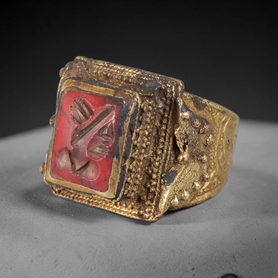 Antique Qajar Dynasty Red Jasper Symbolic Intaglio Ring - Size 11 US, 90FY: Crafted from gilt brass with a substantial square bezel, this ring features a carved red jasper intaglio stone at its center, incised with a detailed stylized symbolic motif-an amuletic symbol of prot