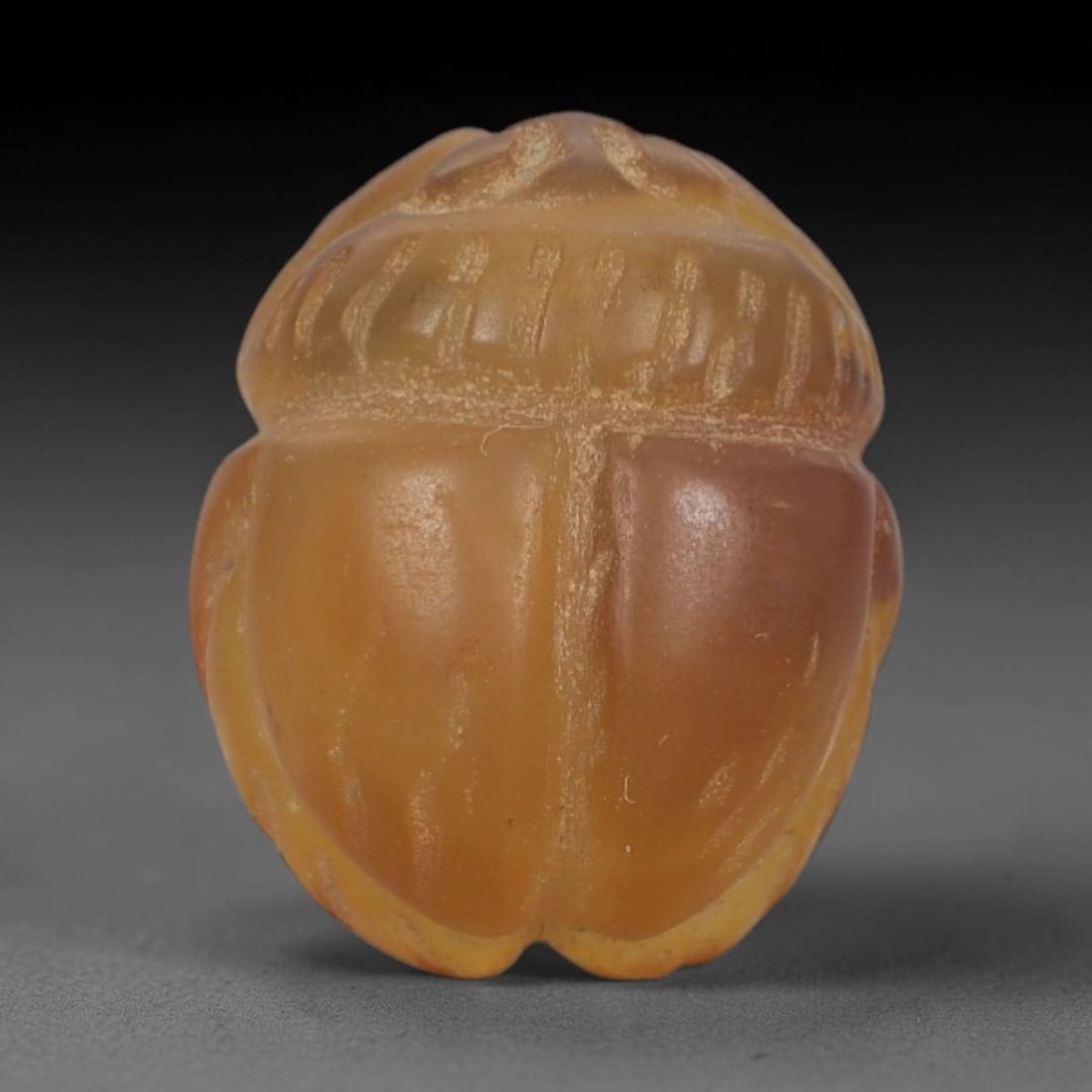 Ancient Banded Agate Scarab Amulet - Egyptian Figurine, 81AJ: Carved from warm banded agate with creamy white and amber-orange natural inclusions, this amulet is formed as a stylized scarab beetle with subtle linear detailing to define segmented wing cases and b