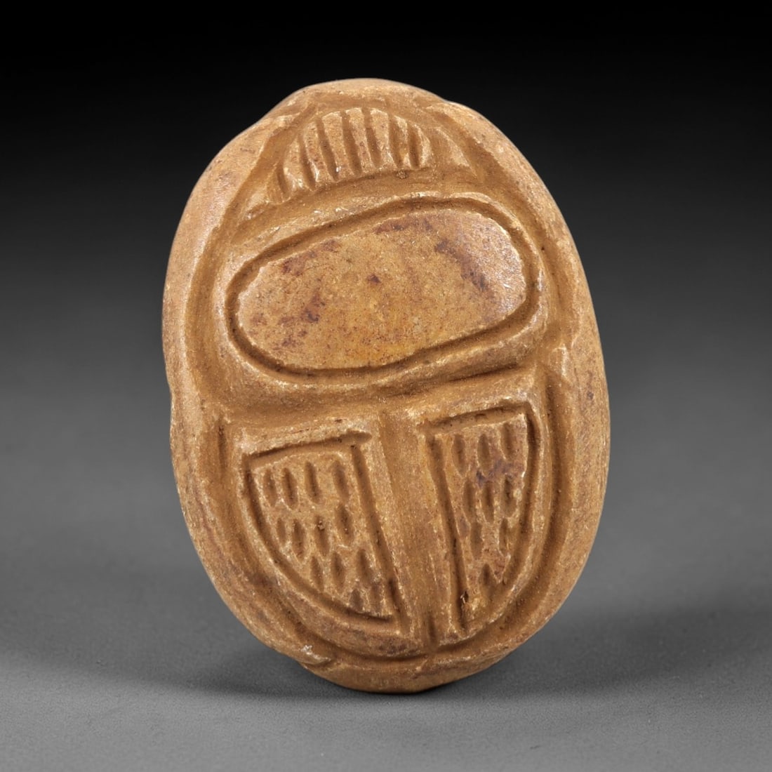 Ancient Steatite Scarab Seal - Near Eastern Amulet, 75AL: Carved from tan steatite, this scarab seal depicts the classic beetle form on its dorsal surface, with incised lines defining the elytra and segmented body. The ventral face features a stylized hierog