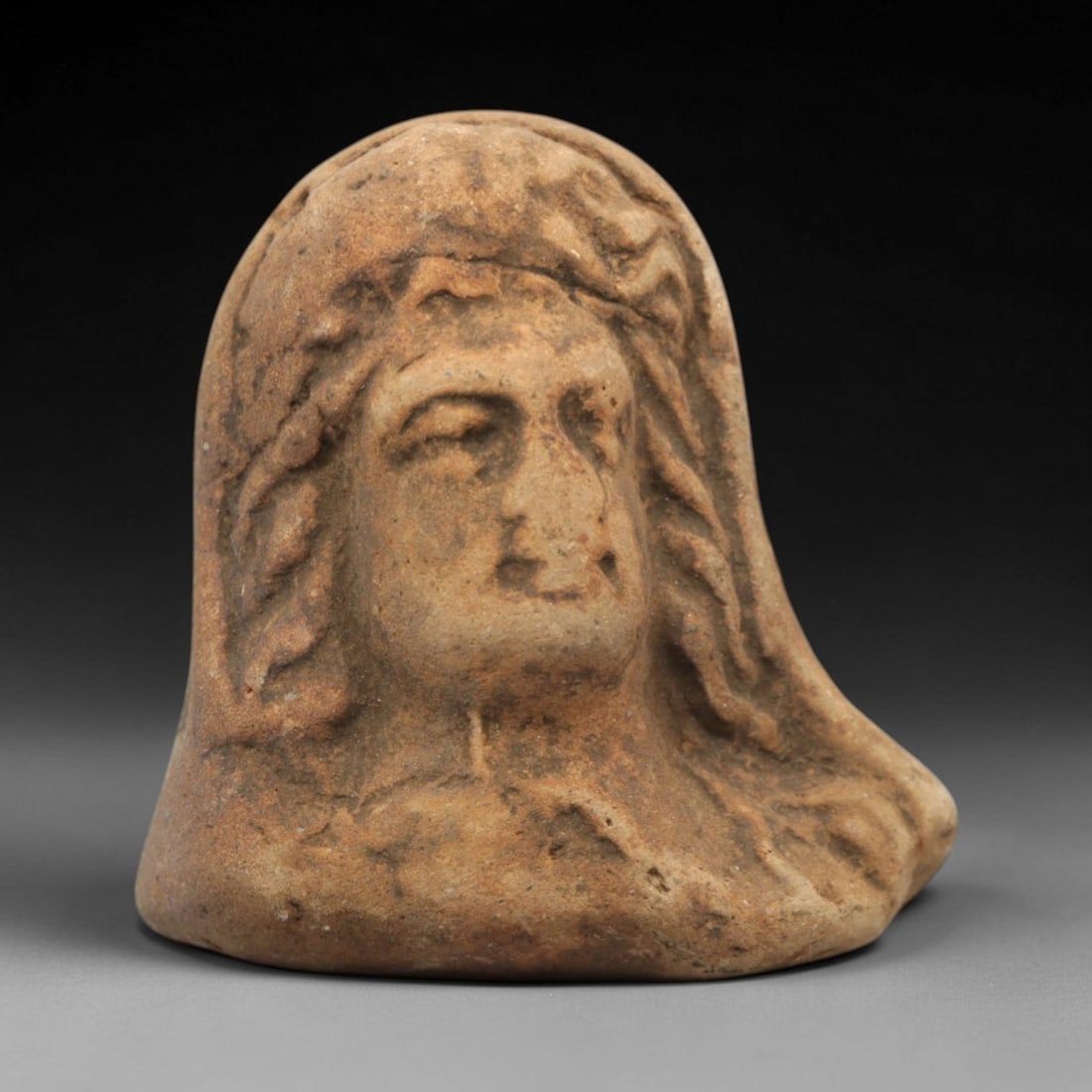Ancient Terracotta Bust - Near Eastern Figural Head, 65ZV: Crafted from fired terracotta, this piece features a high-relief bust of a veiled male figure, with incised and molded details defining the wavy hair, facial features, and draped veil framing the head