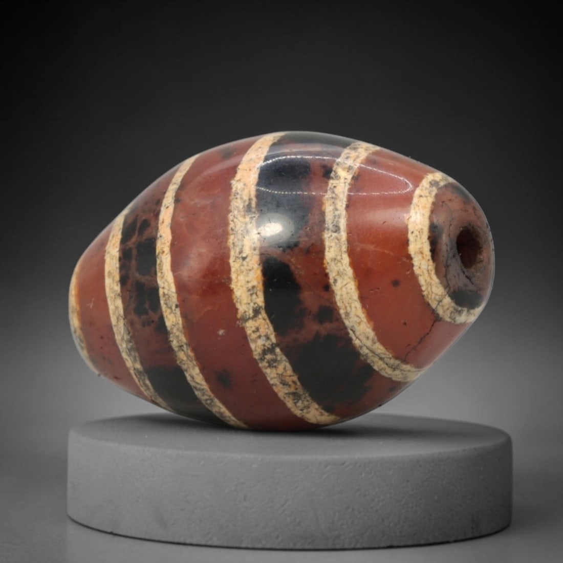 Ancient Carnelian Etched Dzi Bead - Himalayan Amulet, 71XV: Crafted from rich carnelian, this bead features bold etched white parallel band patterns alternating with dark inlaid sections, executed in the traditional Himalayan Dzi bead craftsmanship. The form i