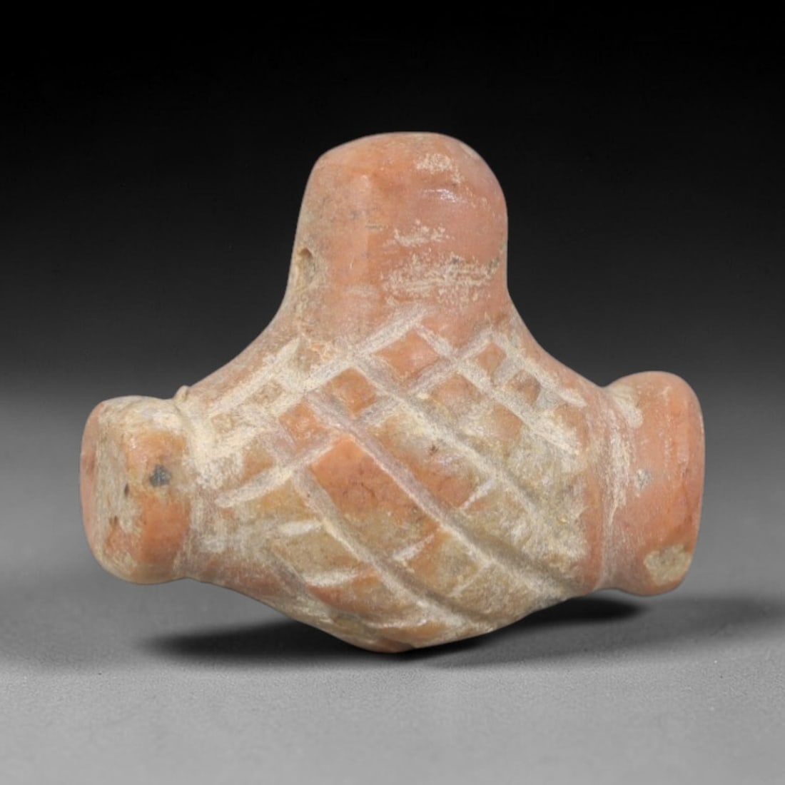 Ancient Red Stone Basket Amulet - Near Eastern Ritual Pendant, 47AR: Carved from warm reddish stone, this amulet features a compact, basket-shaped form with incised crisscross lattice patterns across its body, evoking traditional woven container imagery. A small suspen