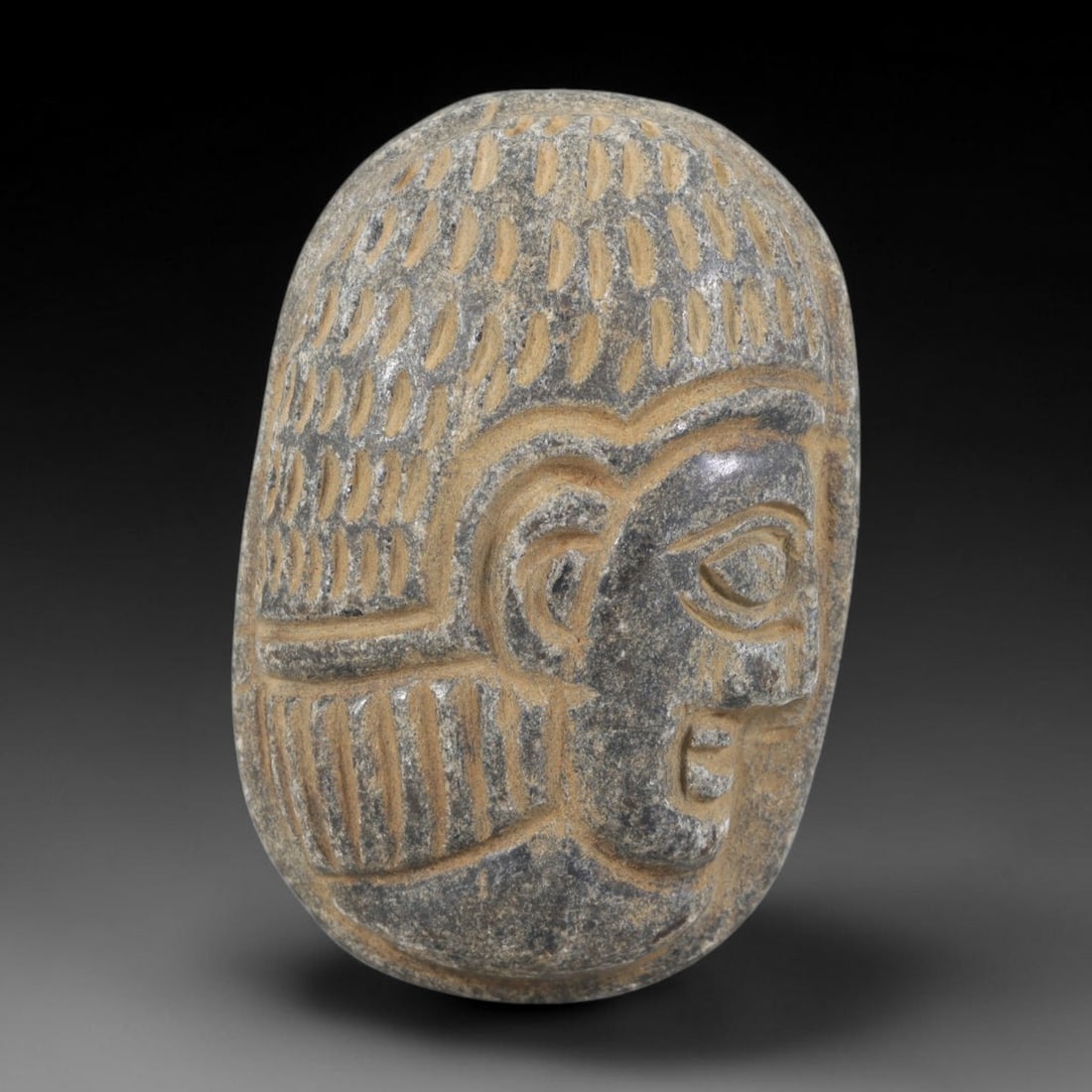 Ancient Stone Amulet - Near Eastern Bust Plaque Pendant, 38FY: Carved from dark stone, the amulet is an oval plaque crafted in the ancient Near Eastern style, featuring a raised relief portrait of a human bust in profile. The surface bears incised details renderi