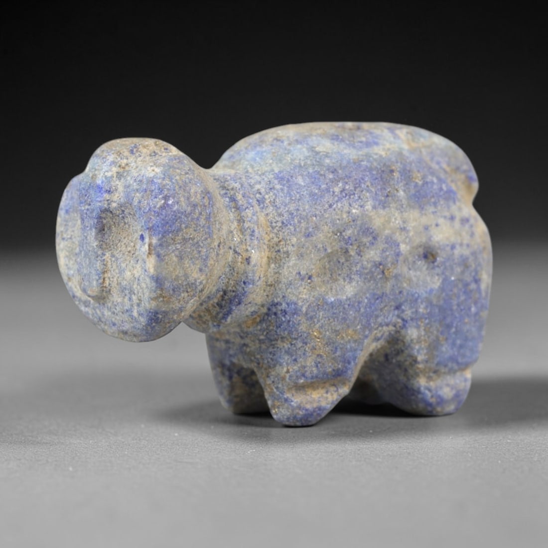 Ancient Lapis Lazuli Anthropomorphic Amulet - Near Eastern Figure, 56AR: Carved from rich blue lapis lazuli with natural calcite and pyrite inclusions, this anthropomorphic amulet depicts a stylized humanoid form with a rounded head, simplified facial features, and compact