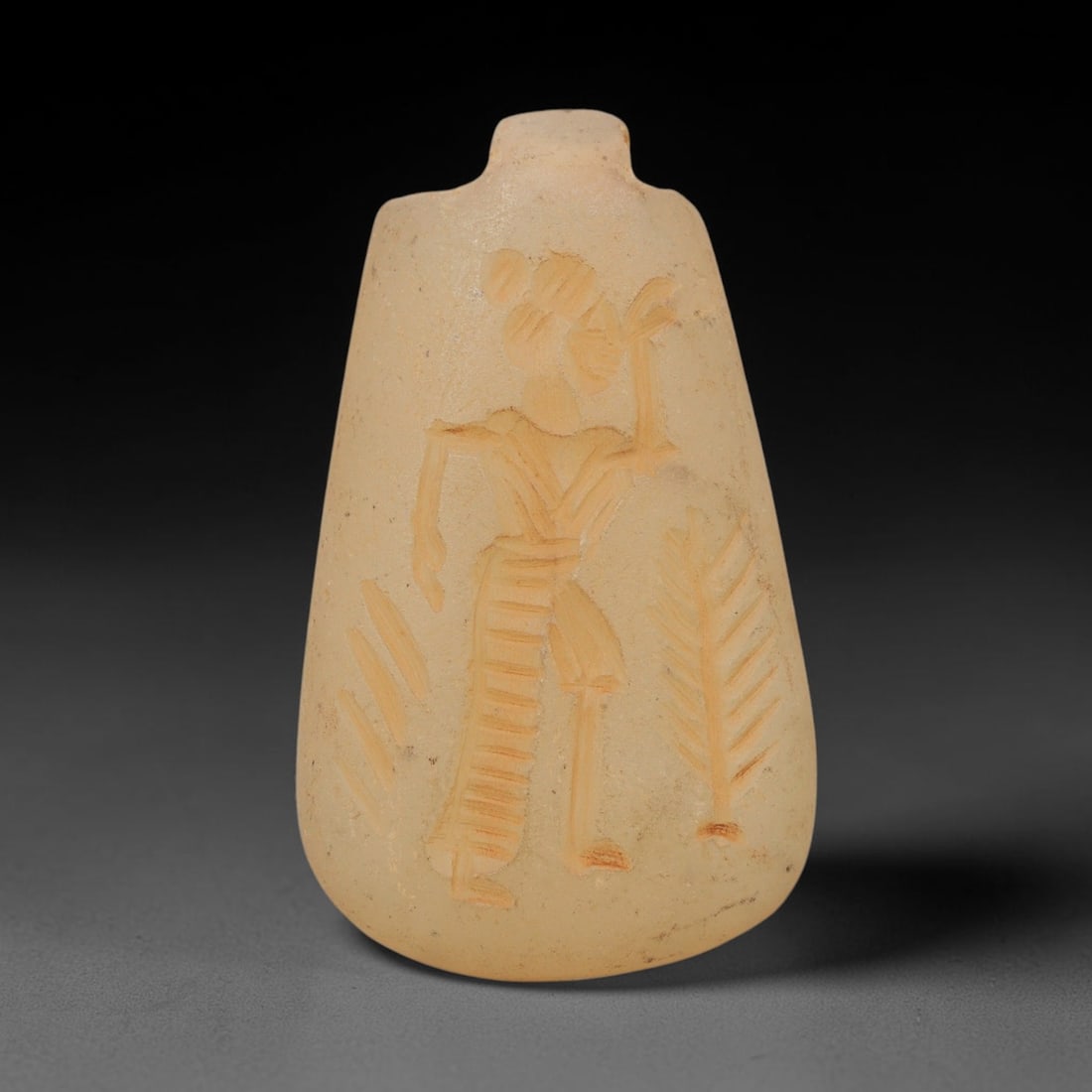 Ancient Chalcedony Pendant - Near Eastern Anthropomorphic Amulet, 29WJ: Carved from chalcedony, this ancient Near Eastern amulet pendant features a finely incised relief of a standing anthropomorphic figure, rendered with precise linear carvings that define the figure's a