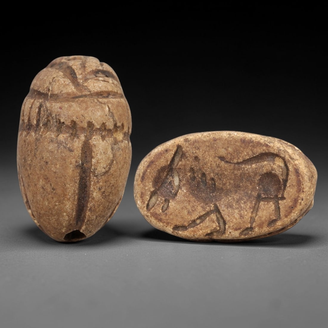 Ancient Steatite Scarab Stamp Seal - Near Eastern Bovine Figure, 82AM: Carved from light brown steatite, this Near Eastern scarab stamp seal features a dorsal scarab pattern with incised linear details defining the elytra and decorative elements, while the ventral face d