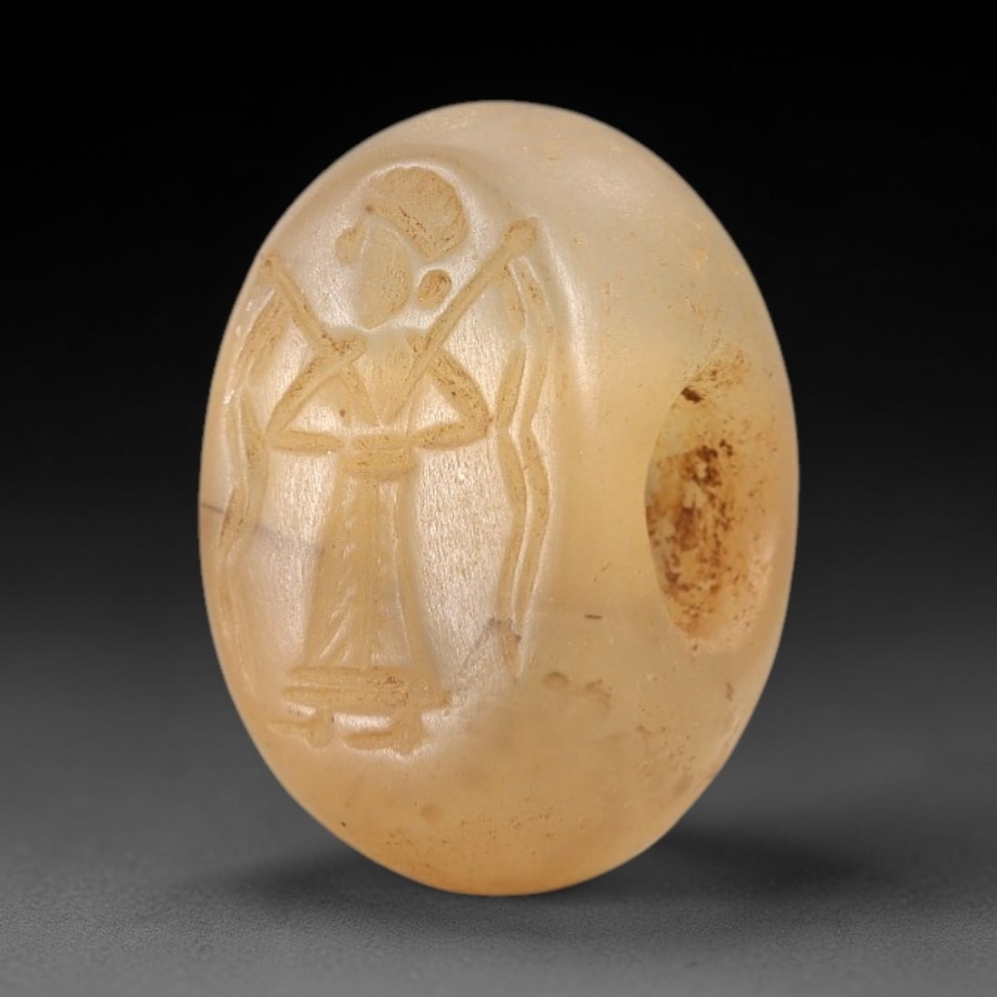Ancient Chalcedony Hemispherical Stamp Seal - Near Eastern Winged Figure Amulet, 33AN: This ancient Near Eastern hemispherical stamp seal is carved from translucent, pale amber chalcedony, with a smooth, polished surface and subtle natural patina. The seal's oval face depicts a winged a