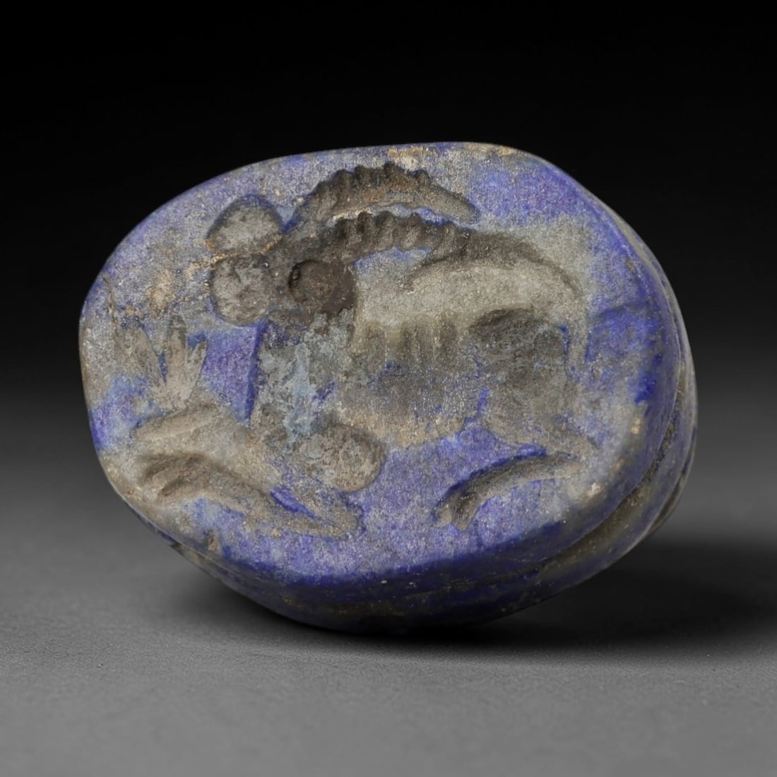 Ancient Lapis Gazelle Amulet - Near Eastern Figurine, 15AH: Carved from lapis lazuli, this ancient Near Eastern amulet features a stylized gazelle motif with intricate linear detailing typical of regional glyptic art. The material exhibits deep blue coloration