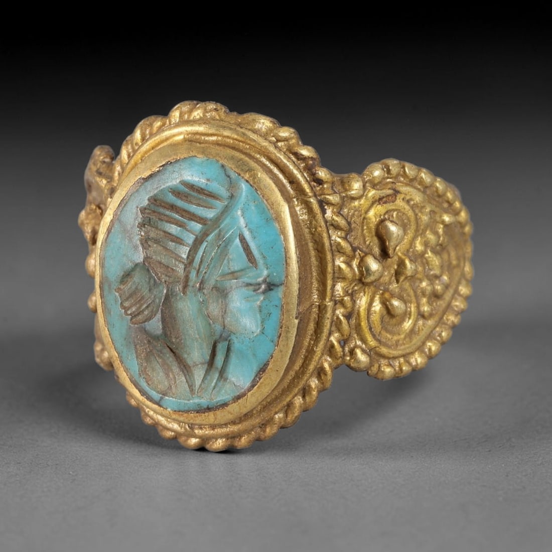 Antique Qajar Dynasty Turquoise Intaglio Ring - Size 9 US, 82FY: Crafted from gilt metal with an ornate oval bezel, this ring features a carved turquoise intaglio stone at its center, depicting an incised profile portrait motif characteristic of Qajar-era Persian s