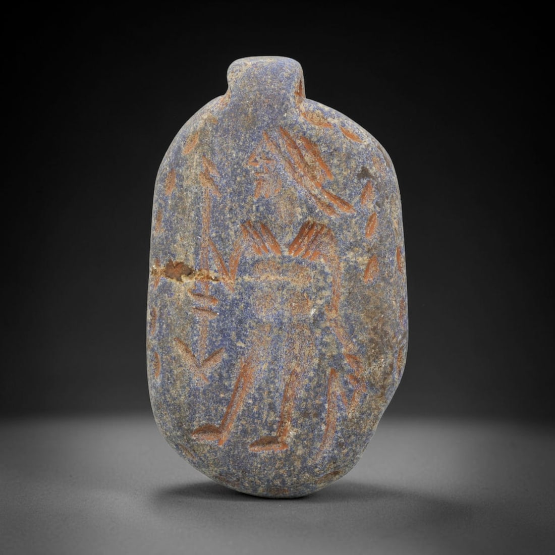 Ancient Lapis Lazuli Amulet - Near Eastern Warrior Figure, 90ZT: Carved from lapis lazuli, this amulet features a relief depiction of a standing warrior figure, rendered in the stylized glyptic tradition of the ancient Near East. The figure is detailed with incised