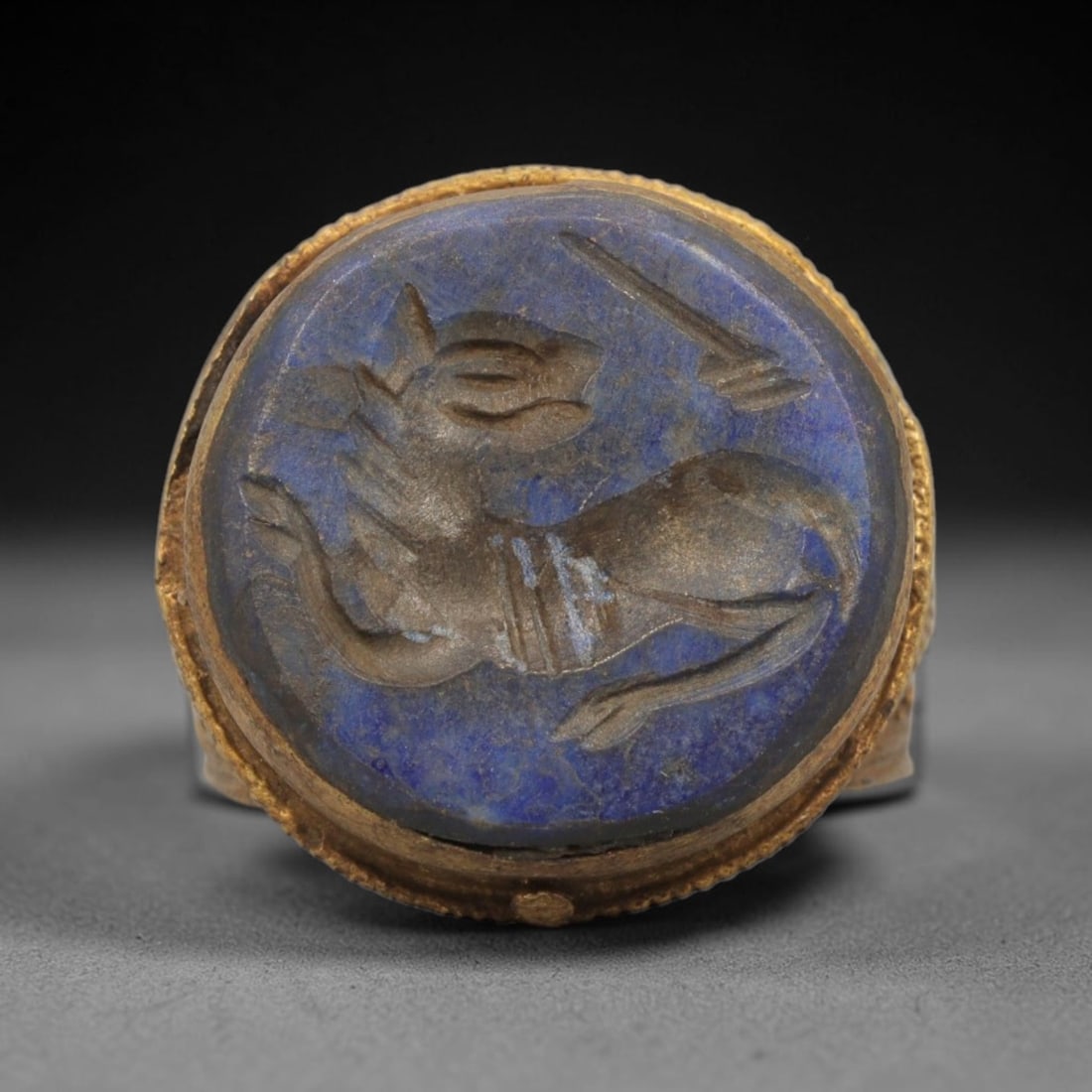 Antique Qajar Dynasty Brass Lapis Lazuli Intaglio Ring - Size 7 US, 65ZX: This antique Qajar dynasty brass intaglio ring features a round lapis lazuli intaglio inset carved with a detailed mythical creature (ibex/griffin) motif, set within an ornate brass mount with a twist