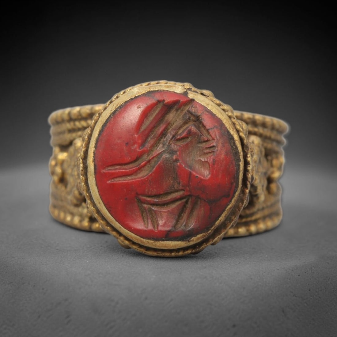 Antique Qajar Dynasty Brass Red Stone Intaglio Ring - Size 9 US, 75ZX: This antique Qajar dynasty brass intaglio ring features a round red stone intaglio inset carved with a detailed profile portrait, set within an ornate wide brass band adorned with layered granular bea
