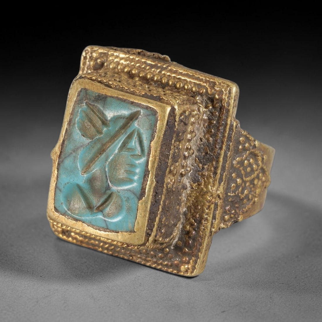 Antique Qajar Dynasty Turquoise Intaglio Brass Ring - Size 8 US, 62BA: Crafted from brass, this ring features a square-set turquoise intaglio panel carved with a stylized profile figure, executed in the traditional Qajar style. The brass band exhibits a textured, granula