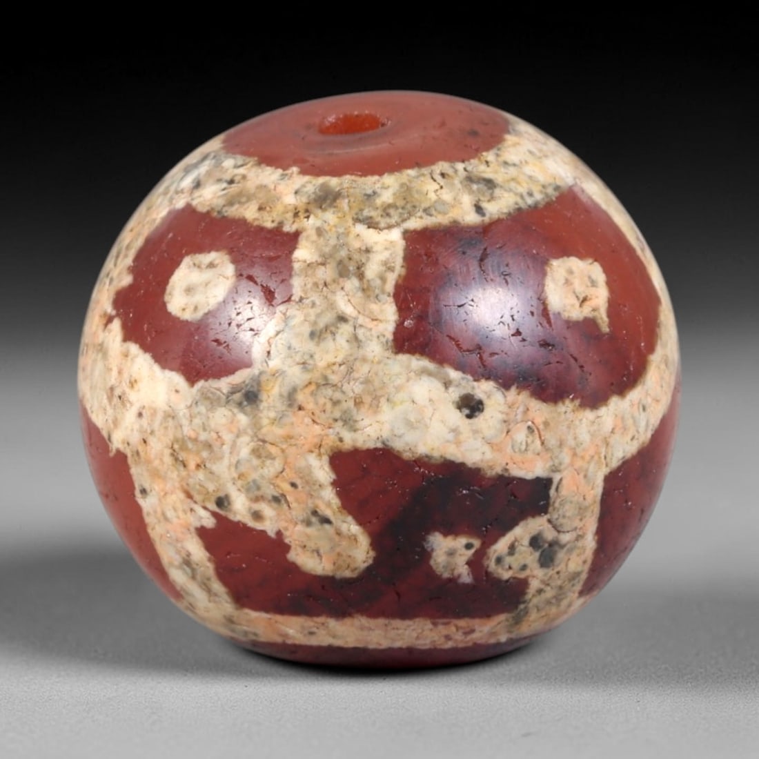 Ancient Carnelian Etched Bead - Himalayan Amulet, 94AR: This ancient spherical bead is carved from polished carnelian, adorned with contrasting white etched geometric and circular motifs across its surface. The bead features a central drilled suspension ho