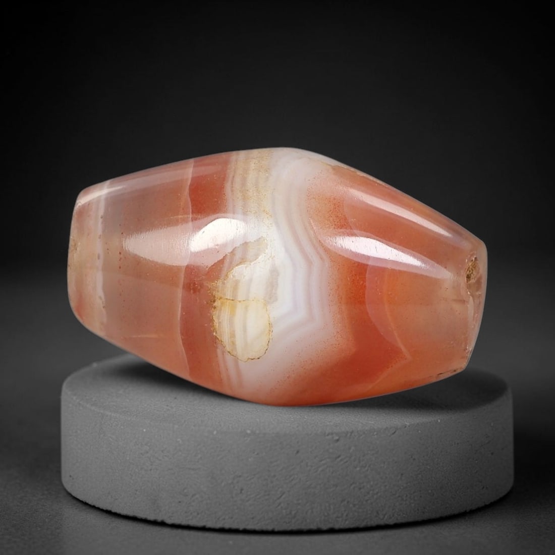 Ancient Agate Bead - Indus Valley Bicone Pendant: Carved from banded agate, the bead exhibits a symmetrical bicone form with smooth, polished surfaces that highlight the natural concentric banding of the stone, ranging from warm peach and terracotta