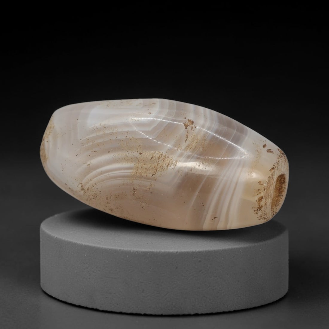 Ancient Banded Agate Bead - Western Asiatic Miniature Amulet: This bead is expertly carved from naturally banded translucent agate, showcasing fine lapidary craftsmanship consistent with the ancient bead-making traditions of the Indus Valley and Bactrian regions