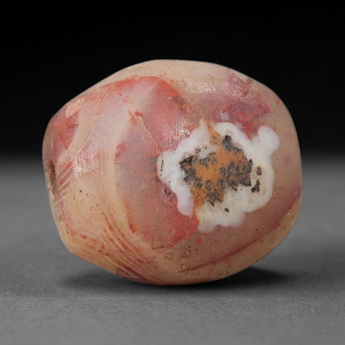 Ancient Agate Bead - Silk Road Natural Form Amulet, 97BC: Carved from banded agate (carnelian variant), the bead features a smooth, naturally shaped barrel form with a polished surface that highlights the stone's striking warm reddish-pink base, accented by