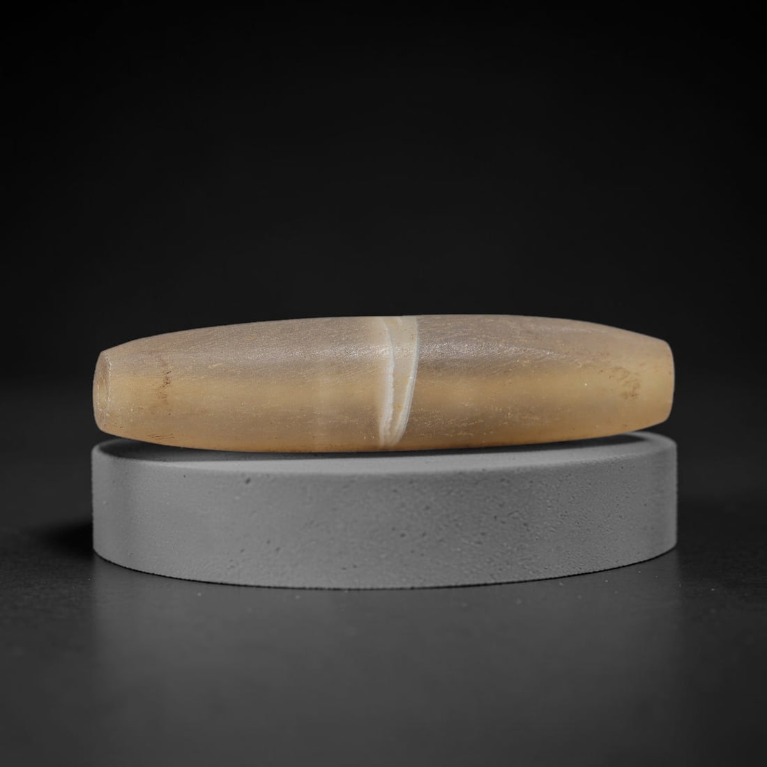 Ancient Agate Bead - Silk Road Bicone Amulet, 83BD: Carved from banded agate, the bead exhibits an elongated bicone form with a smooth, polished surface that highlights the stone's warm honeyed translucency and a distinct central white band, characteri