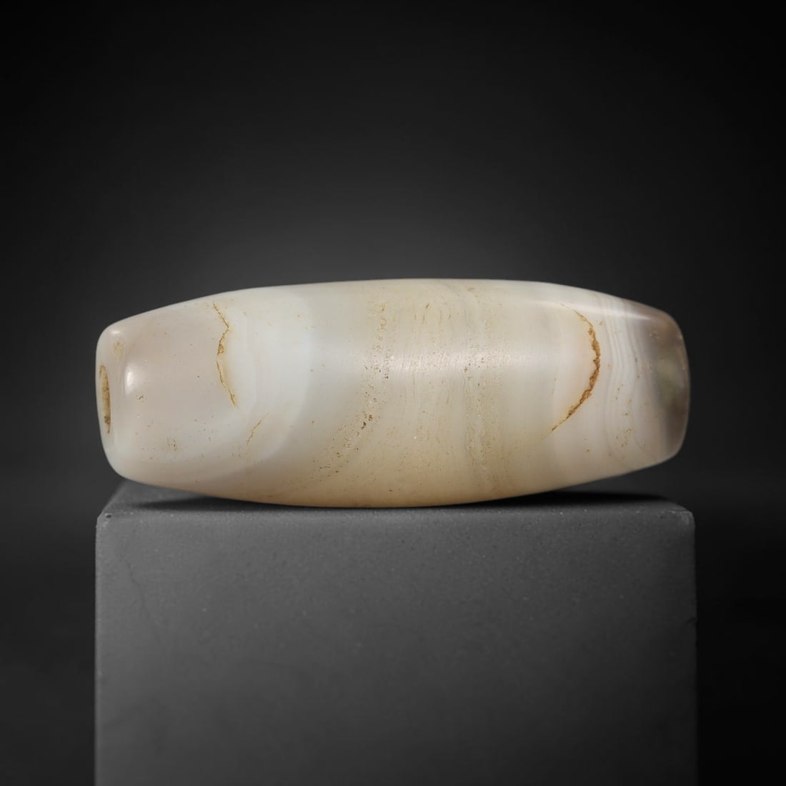 Ancient Agate Bead - Silk Road Cylinder Amulet: Carved from banded agate, the bead features a smooth cylindrical barrel form with a polished surface that highlights the stone's soft milky-white and warm cream concentric banding, accented by subtle