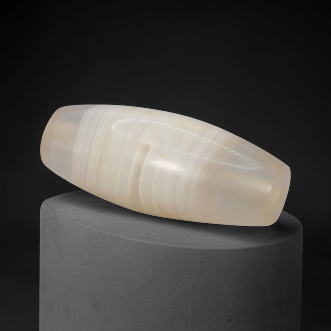 Ancient Agate Bead - Indus Valley Bactrian Pendant: This bead is carved from finely banded translucent agate, showcasing expert lapidary workmanship consistent with ancient bead-making traditions of the Indus Valley and Bactrian regions. The elongated