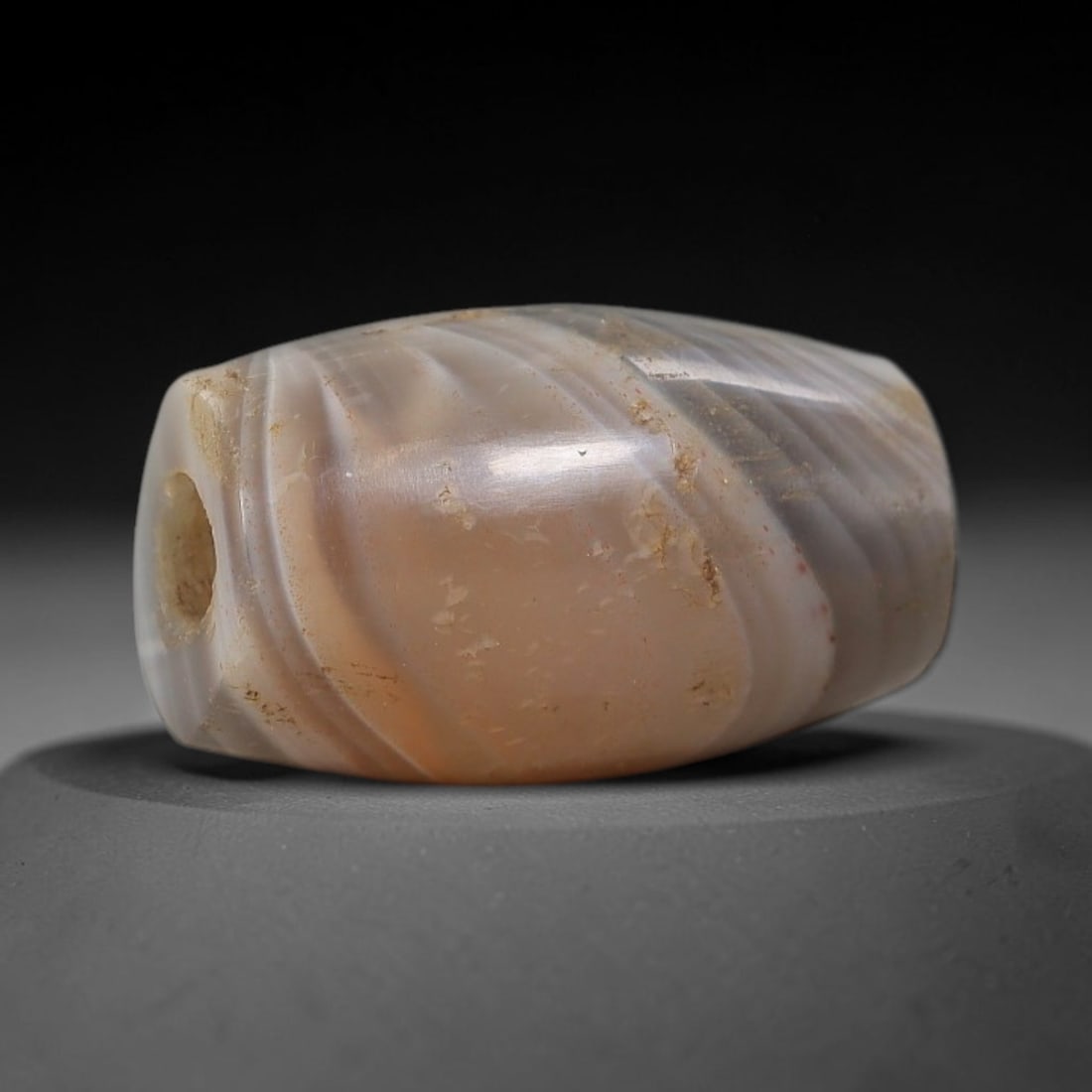 Ancient Agate Bead - Silk Road Miniature Amulet: Carved from banded agate, the bead features a short cylindrical barrel form with a smooth, polished surface that showcases the stone's natural diagonal concentric banding, ranging from translucent mil