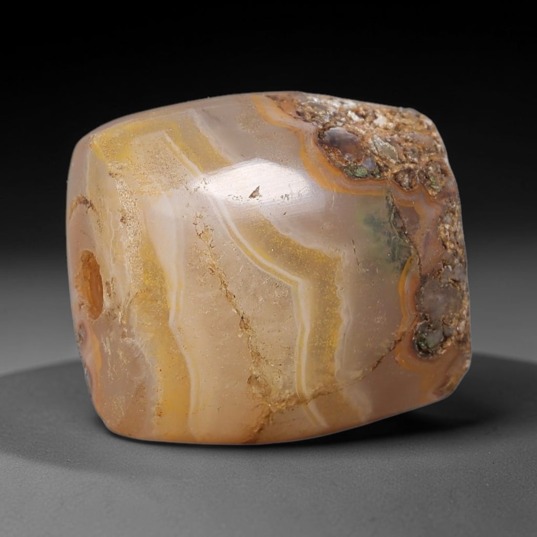 Ancient Agate Bead - Silk Road Miniature Amulet: Carved from banded agate, the bead features a faceted barrel form with a smooth, polished surface that highlights the stone's natural concentric banding, ranging from warm honey and golden yellow to t