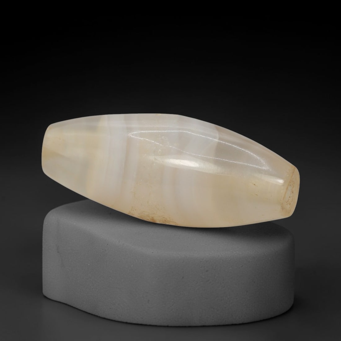 Ancient Banded Agate Bead - Indus Valley Bactrian Pendant: This bead is expertly carved from subtly banded translucent agate, showcasing masterful lapidary craftsmanship consistent with ancient bead-making traditions of the Indus Valley and Bactrian regions.
