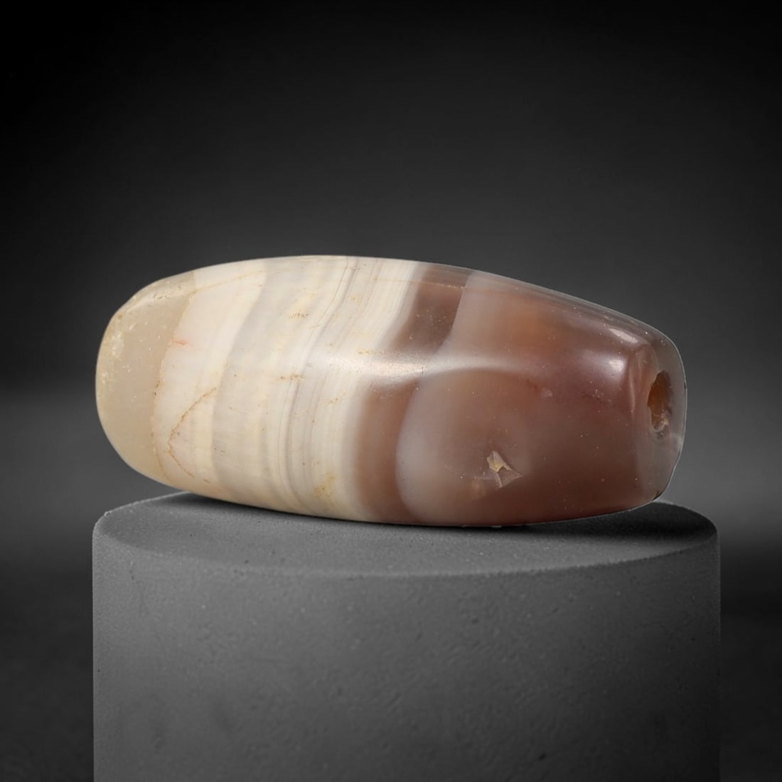Ancient Agate Bead - Silk Road Cylinder Amulet: Carved from banded agate, the bead features a cylindrical barrel form with a smooth, polished surface that showcases the stone's natural concentric banding, ranging from translucent milky white to war