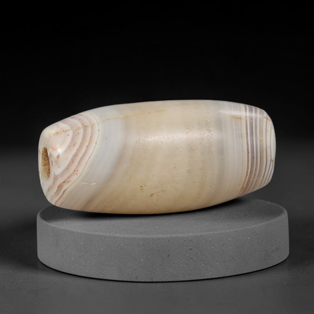 Ancient Agate Bead - Silk Road Cylinder Amulet: Carved from banded agate, the bead features a cylindrical barrel form with a smooth, polished surface that highlights the stone's natural concentric banding, ranging from creamy white and soft taupe t