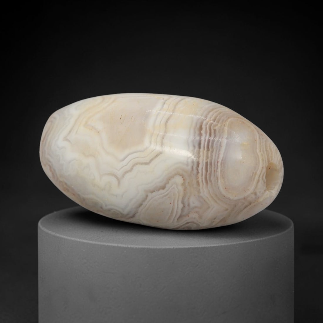 Ancient Agate Bead - Western Asiatic Amulet: This bead is carved from intricately banded agate, exhibiting fine lapidary workmanship consistent with ancient bead-making traditions of Western Asiatic regions such as Bactria and the Silk Road corr