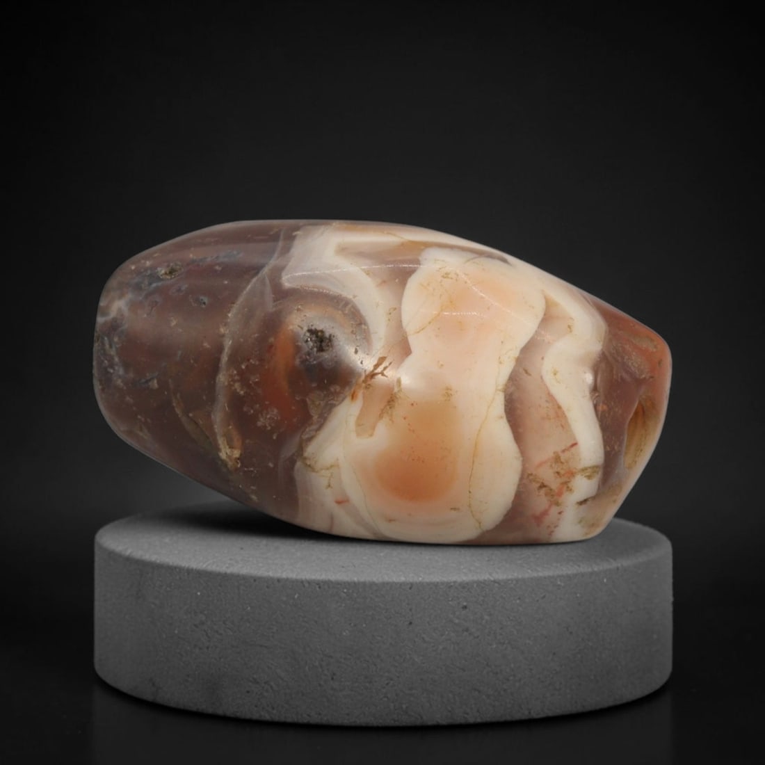 Ancient Agate Bead - Silk Road Bactrian Amulet: This bead is carved from richly patterned banded agate, exhibiting expert lapidary craftsmanship characteristic of ancient Bactrian and Silk Road bead-making traditions. The barrel form features a cen