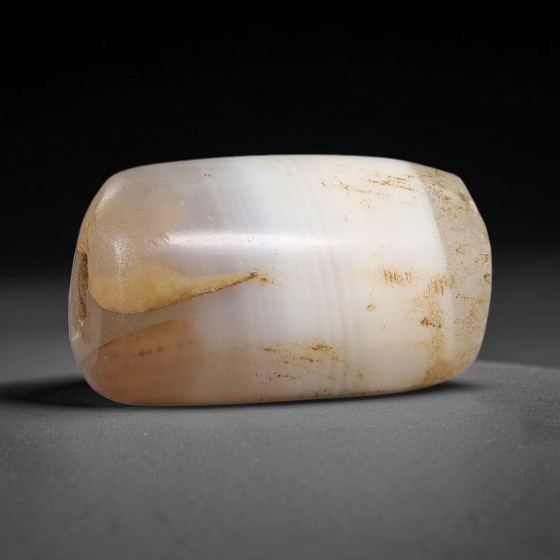 Ancient Agate Bead - Silk Road Cylinder Amulet: Carved from banded agate, the bead features a smooth cylindrical barrel form with a polished surface that highlights the stone's natural concentric banding, ranging from creamy white and soft taupe to
